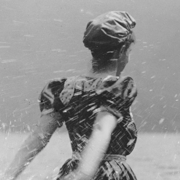 Mujer en la playa, salpicando agua.